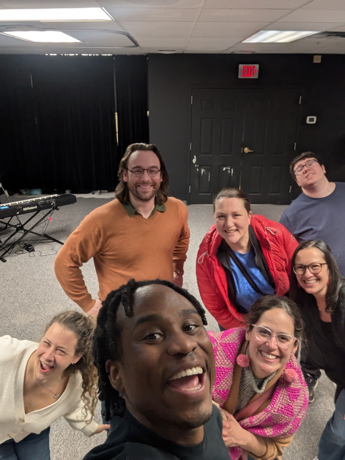 A circle of adults laughing together during an MF Improv class in Natick